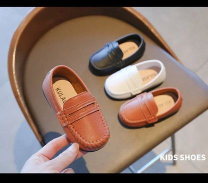 Classic boys' black leather slip-on loafers, a timeless choice for school and elegant outfits.