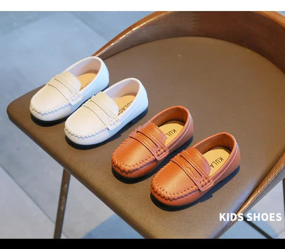 Boys' sturdy black leather slip-on school loafers, featuring a simple and elegant design.