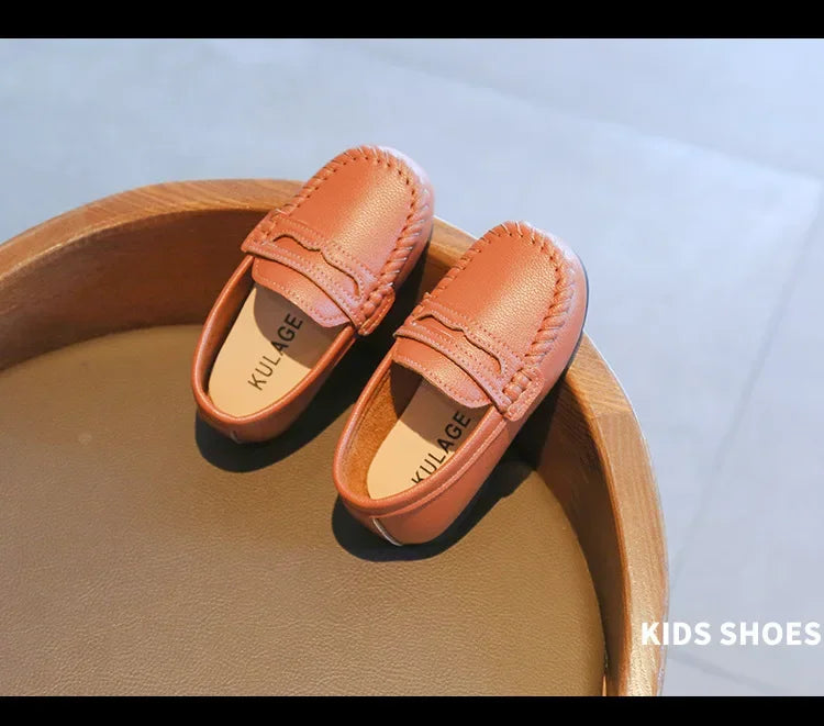 Classic black leather slip-on kids' footwear, reliable for both school and formal settings.