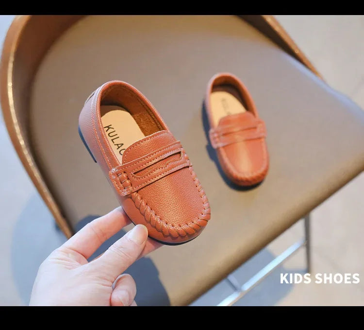 Comfortable black leather slip-on school loafers for children, featuring a timeless design.