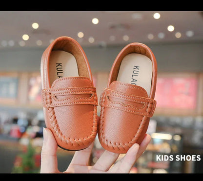 Classic black leather slip-on children's loafers, ensuring comfort and style for school.