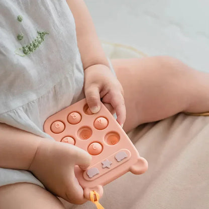 BPA-free silicone phone teether with textured buttons for baby's gum relief and fine motor skill building.