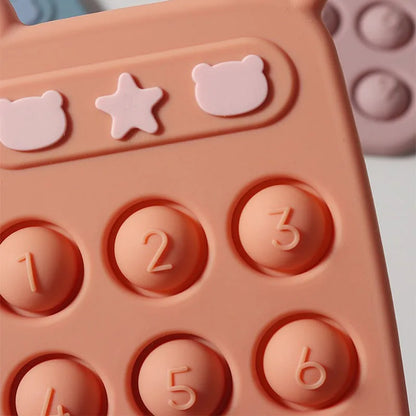 Baby's hand grasping a pink silicone phone teether toy, promoting early development and tactile exploration.