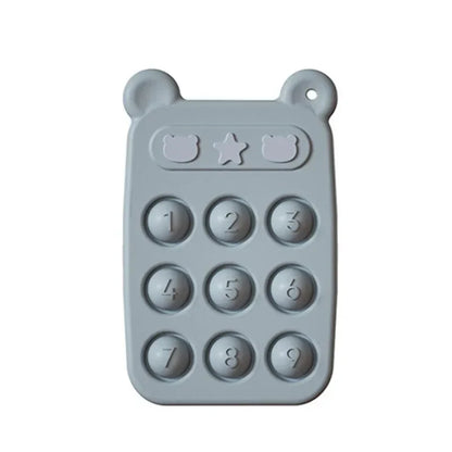Detailed view of the textured surface on a yellow silicone teether phone, designed for baby's oral exploration.