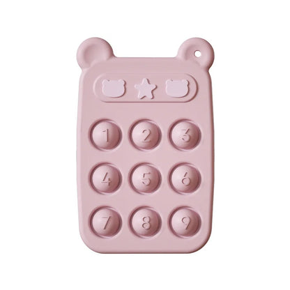 Happy baby chewing on a silicone fidget phone teether, demonstrating its use as a soothing sensory toy.