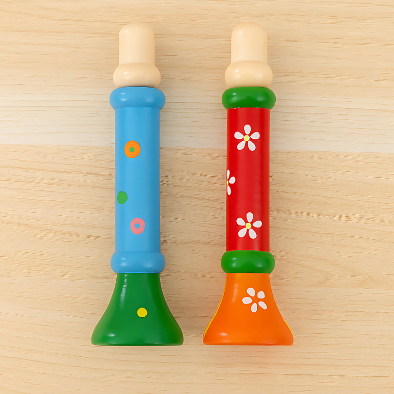 Close-up of a child's hand holding a natural wooden whistle toy, teaching breath control and enhancing fine motor skills.