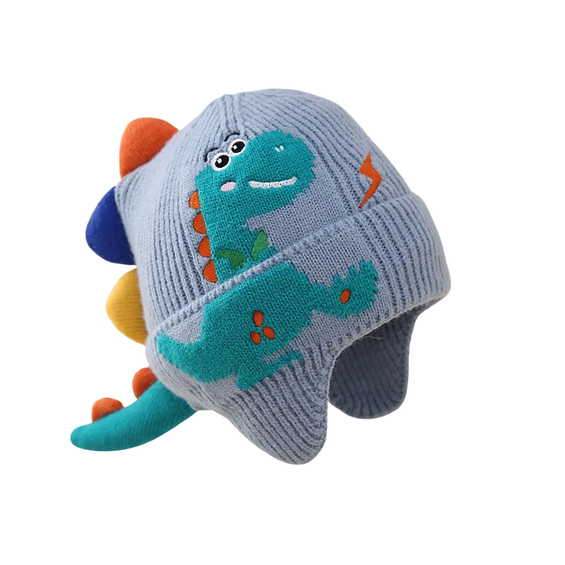 Top-down view of a toddler's knitted dinosaur winter hat, showcasing intricate knit patterns and ear flaps.