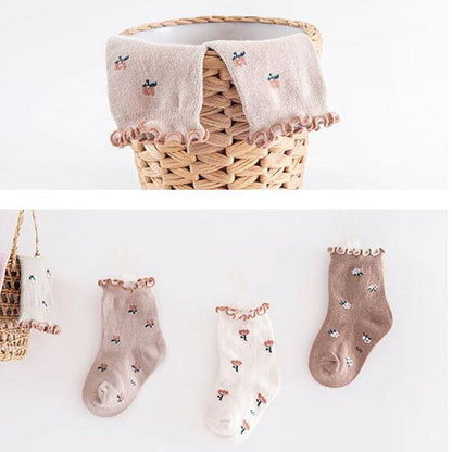 Toddler's feet wearing pink floral ankle socks, highlighting the comfortable cotton material.