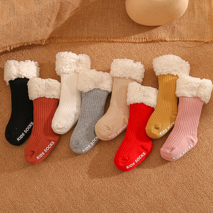 Close-up of a pair of non-slip infant winter socks, showing thick, cozy cotton material