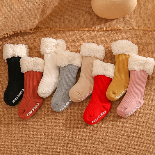Close-up of a pair of non-slip infant winter socks, showing thick, cozy cotton material