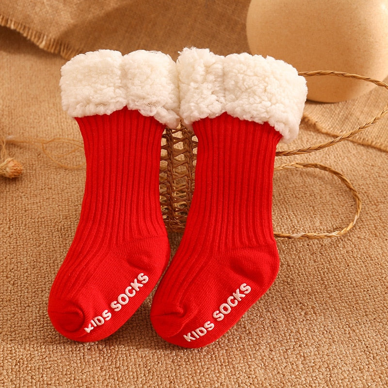 Two pairs of colorful baby's cozy winter socks, stacked neatly against a white background