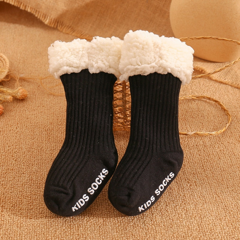 Overhead view of several non-slip baby socks in various patterns, perfect for winter warmth