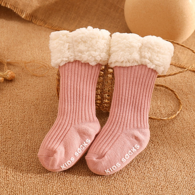 Package containing multiple pairs of baby's non-slip thick winter socks, ready for gifting