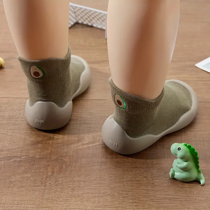 Close-up of a pair of unisex baby barefoot style shoes with flexible sole, cotton upper, and rubber sole