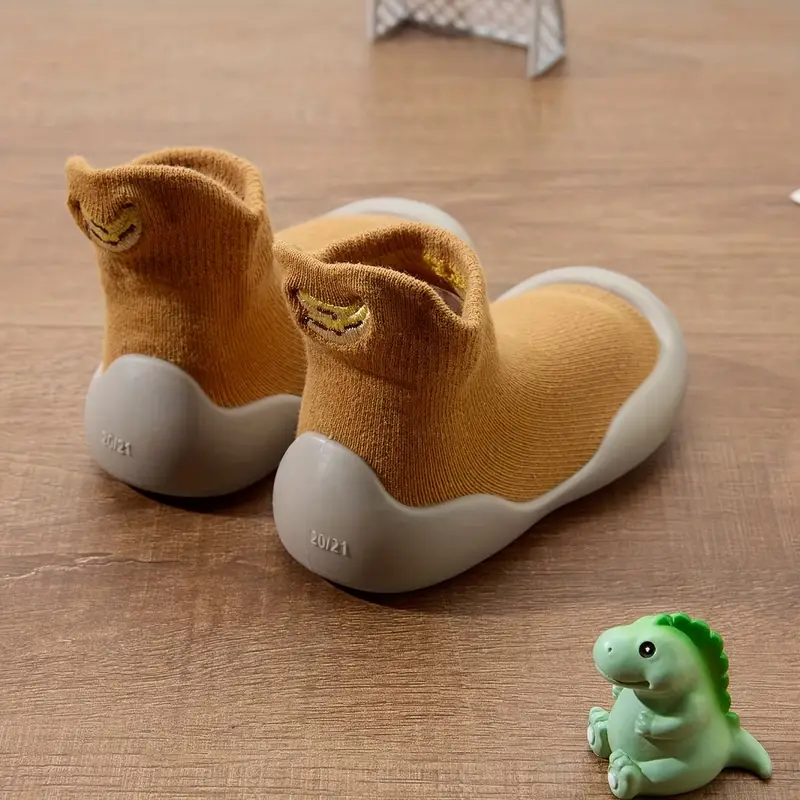 Group of various colored unisex toddler barefoot shoes, all with flexible soles and cotton uppers