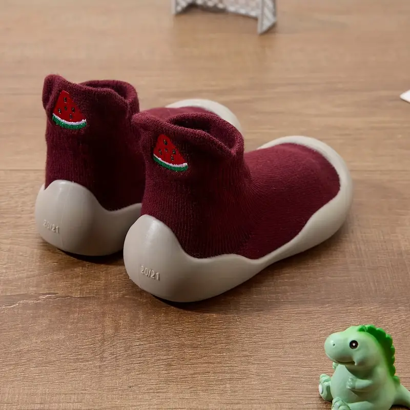 A baby crawling while wearing soft, flexible sole barefoot shoes, perfect for early stages of mobility