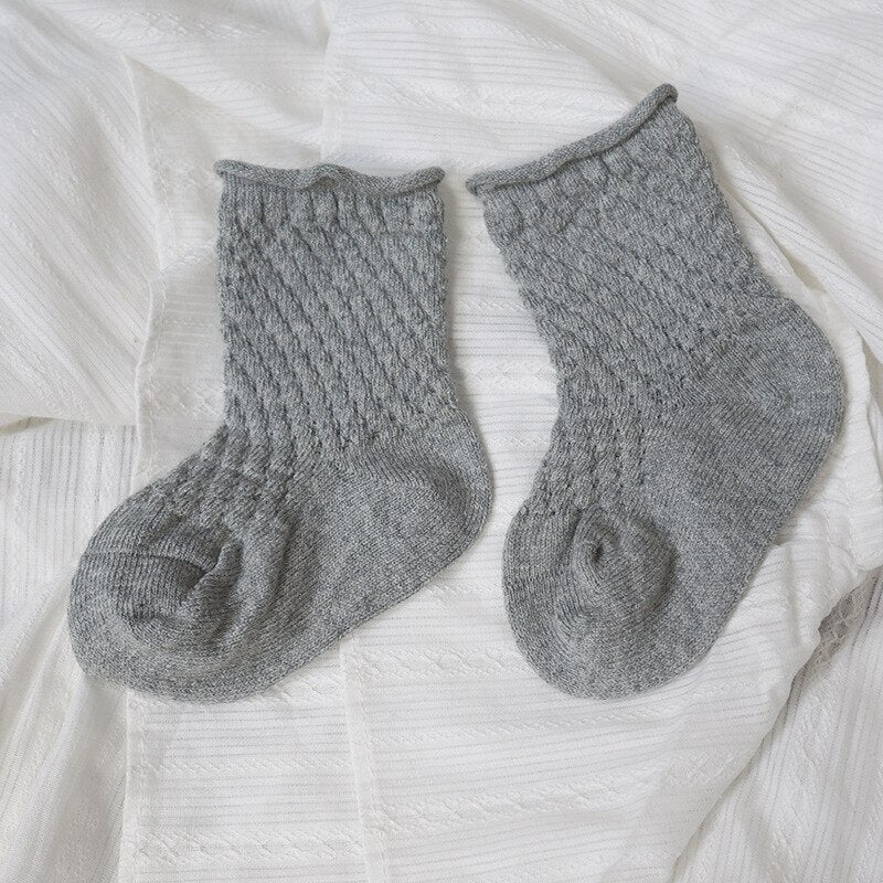 Three pairs of colorful infant cotton mesh breathable ankle socks arranged neatly for children's wear.