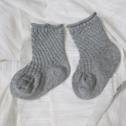 Three pairs of colorful infant cotton mesh breathable ankle socks arranged neatly for children's wear.