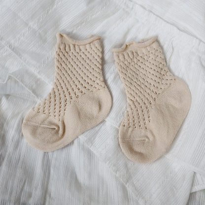 Stack of folded toddler breathable mesh ankle socks in different pastel colors made of soft cotton.