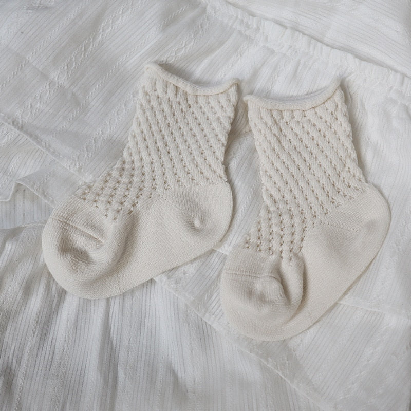 Child's foot wearing a soft cotton mesh breathable ankle sock, showing the ankle length.