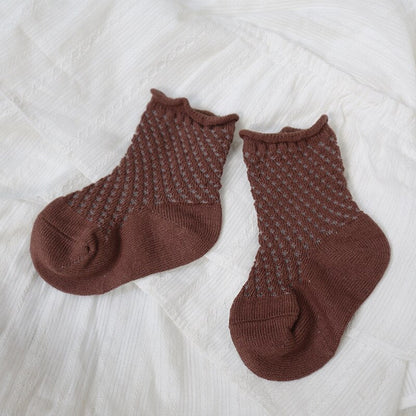 Overhead shot of five pairs of unisex kids cotton mesh breathable ankle socks with tags.