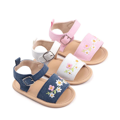 Close-up of baby girl's embroidered floral summer sandals, showcasing delicate stitching and pink hues