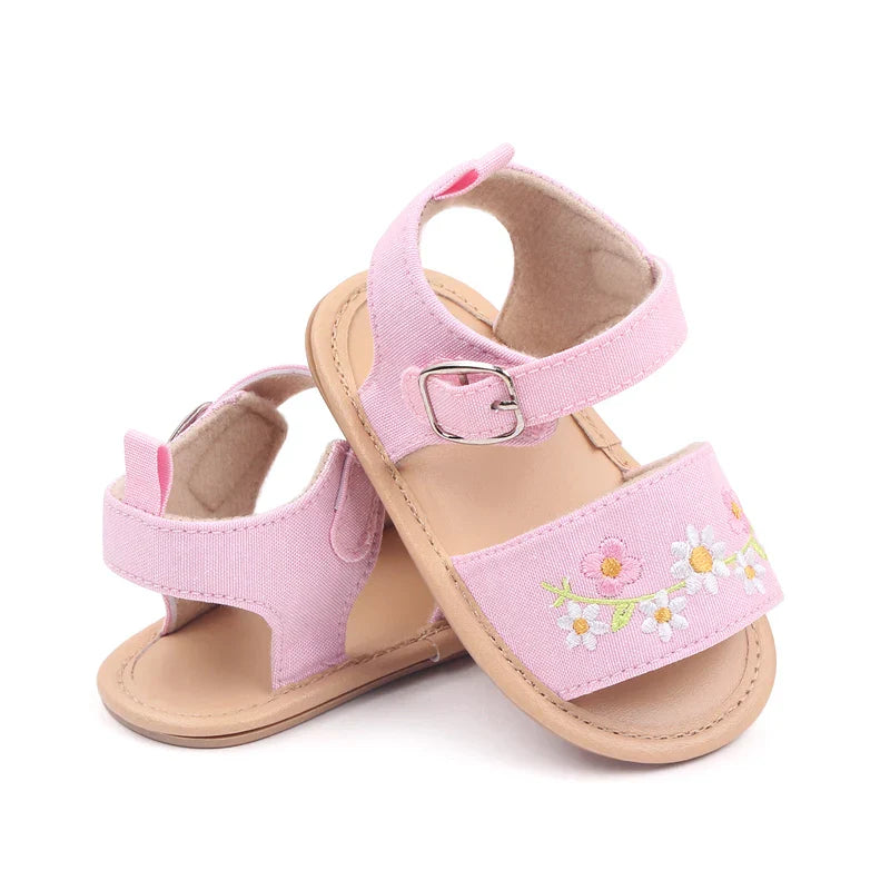 Baby girl modeling embroidered floral summer sandals, soft sole shoes ideal for infant comfort
