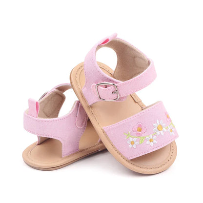 Baby girl modeling embroidered floral summer sandals, soft sole shoes ideal for infant comfort