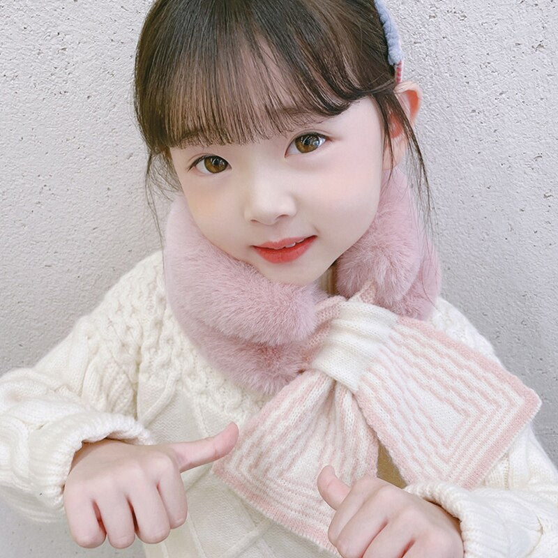 Close-up of baby girl's soft pink faux rabbit fur scarf, perfect for winter warmth and comfort