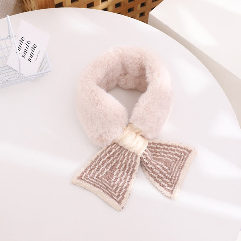 A baby girl smiling, bundled up in a warm, plush faux fur scarf, a must-have for winter warmth