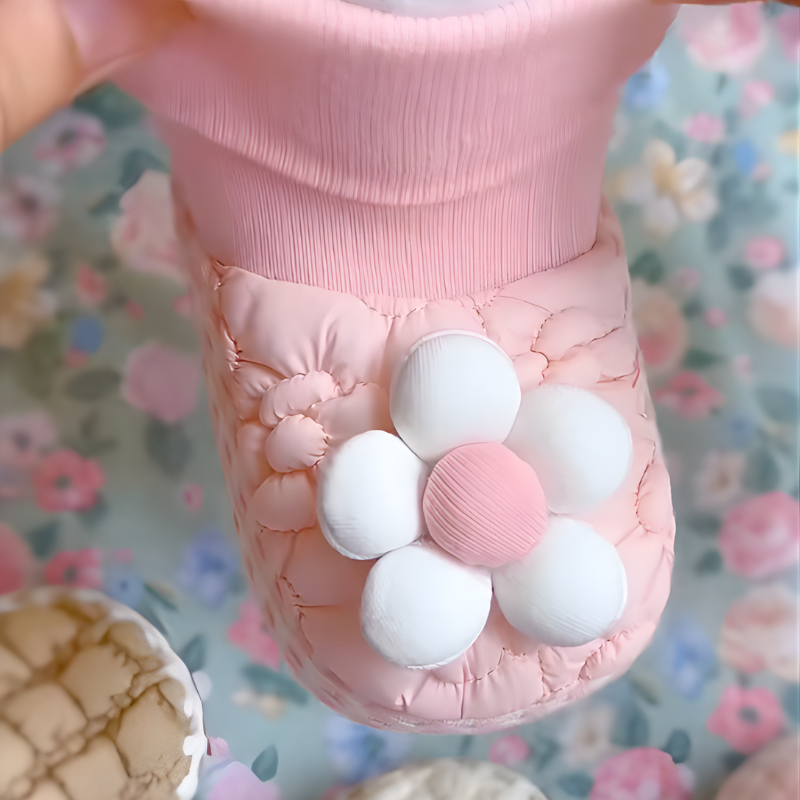 Detailed view of baby booties with floral pattern, showing soft plush material for infants.