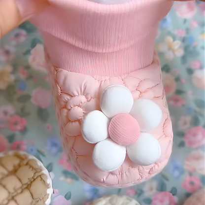Detailed view of baby booties with floral pattern, showing soft plush material for infants.