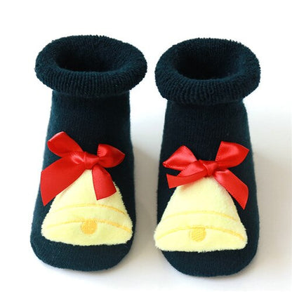 Adorable anti-slip baby Christmas socks on a wooden surface, ready for festive occasions.