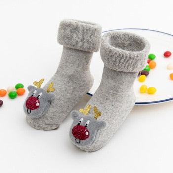 Three pairs of anti-slip baby Christmas socks, showcasing different patterns for holiday wear.