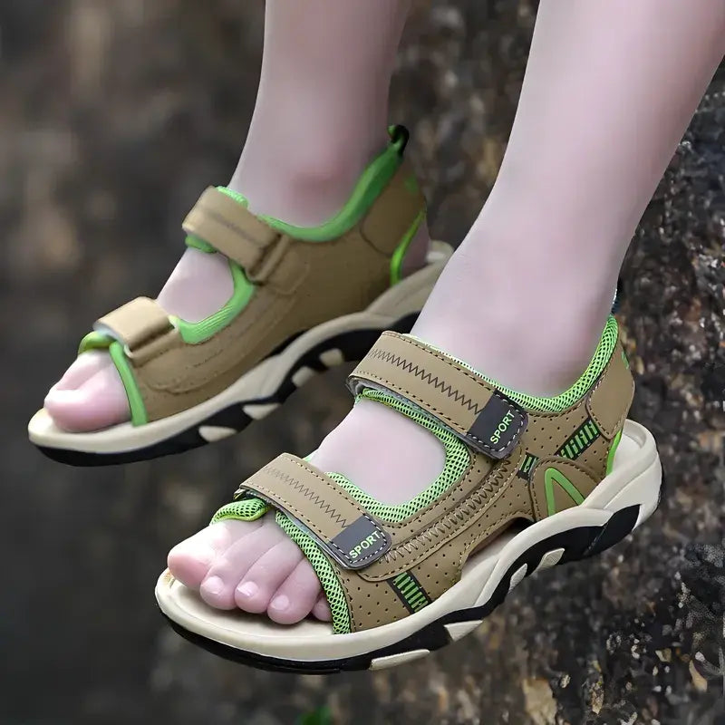 Kids' feet wearing blue non-slip summer sandals, walking on a grassy lawn, highlighting active outdoor play.