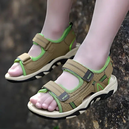 Kids' feet wearing blue non-slip summer sandals, walking on a grassy lawn, highlighting active outdoor play.