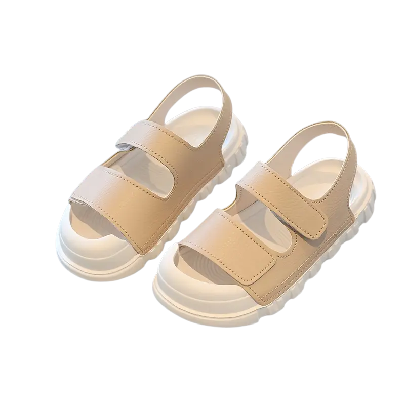 A child's foot wearing a red toe-protecting Velcro sandal, perfect for play and providing secure, comfortable toddler footwear.