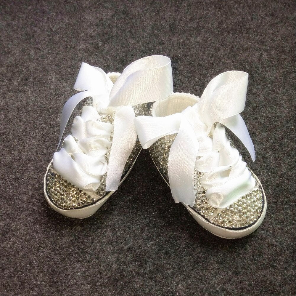 Close-up of pink glitter Mary Jane shoes for baby girls, featuring a delicate bow detail and secure strap.