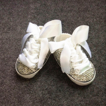 Close-up of pink glitter Mary Jane shoes for baby girls, featuring a delicate bow detail and secure strap.