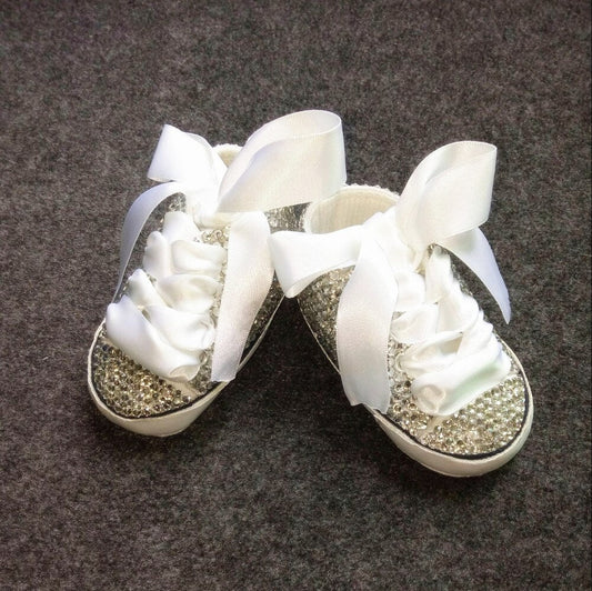 Close-up of pink glitter Mary Jane shoes for baby girls, featuring a delicate bow detail and secure strap.