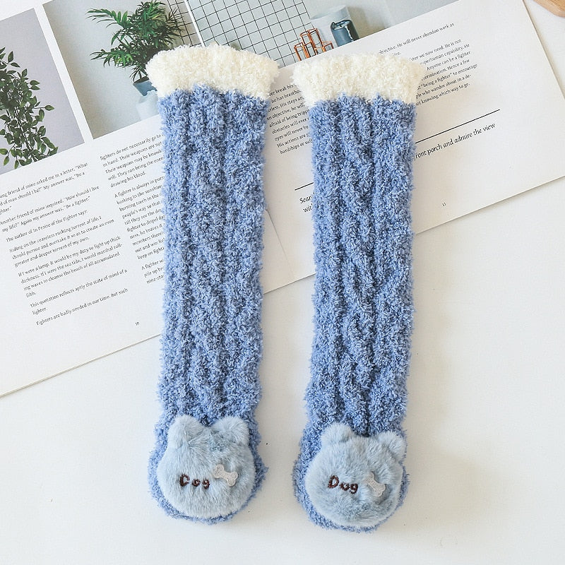 Cute baby wearing blue animal cartoon cotton socks, sitting on a soft blanket