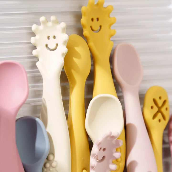 Promoting fine motor skills with a 3-piece silicone baby utensil set: soft spoon and learning fork.