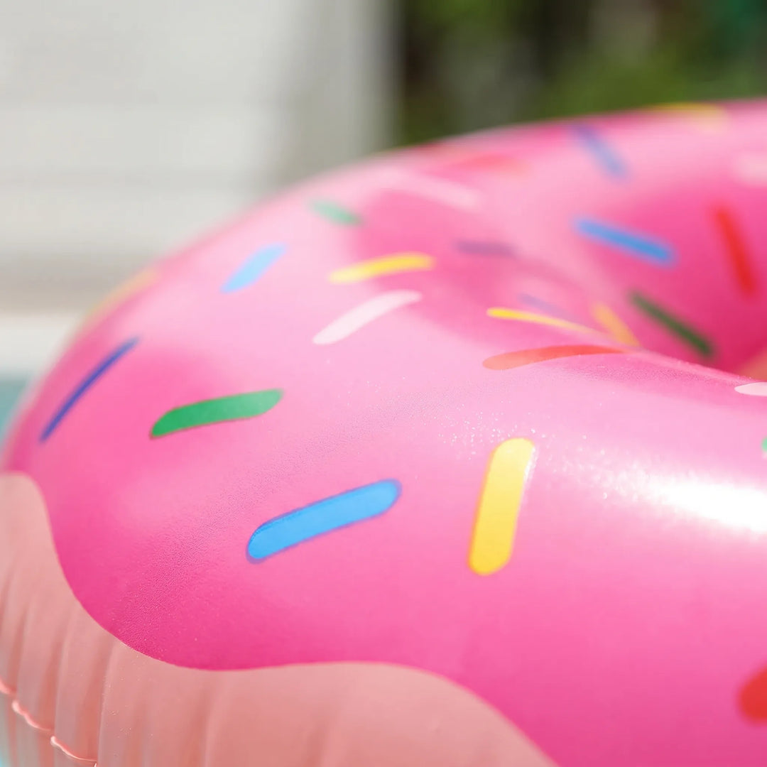 Pastry-themed inflatable donut float. A vibrant summer swim accessory & beach essential for water fun & lounging.