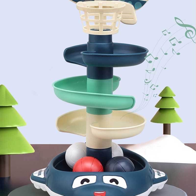 Child delightedly playing with an interactive stacking ball drop toy, learning cause and effect