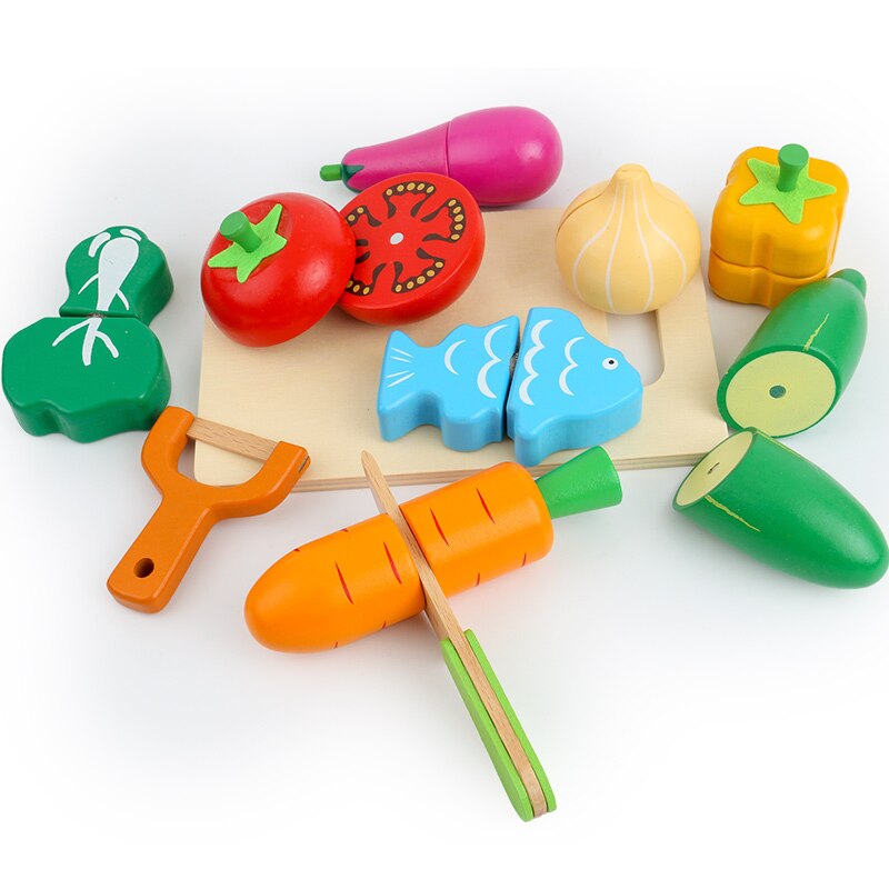 Close-up of a child's hands playing with wooden carrot and apple from the educational toy food set