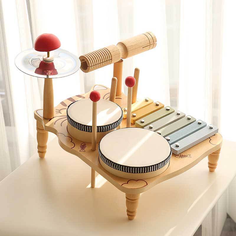 Close-up of a sturdy wooden drum set for children, featuring drums, cymbal, and mallets.