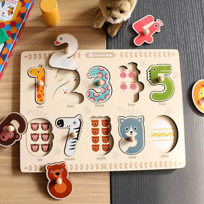 Close-up of a child's hand placing a wooden number piece into an animal puzzle board