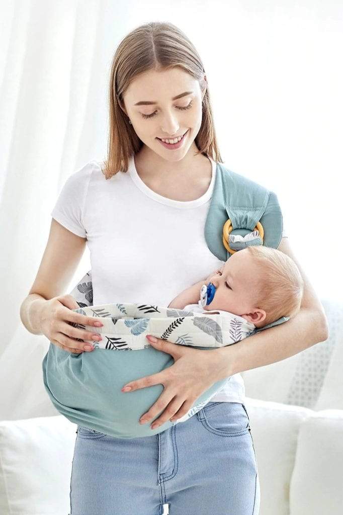 Parent wearing a newborn in a soft grey Comfort 3-in-1 baby wrap carrier, hands-free baby wearing