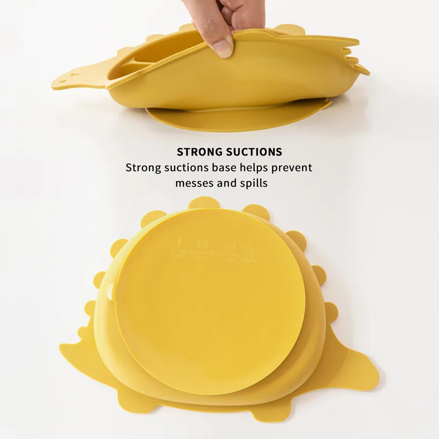 Green silicone suction bowl with matching soft-tip spoon, perfect for toddler self-feeding and weaning.