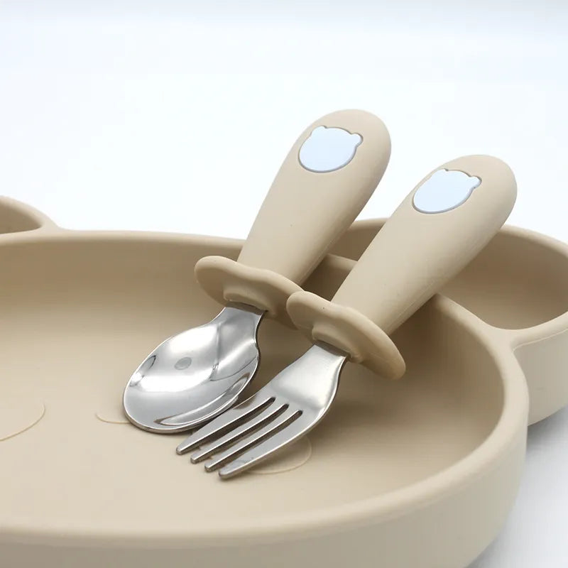 Silicone baby spoon with a comfortable handle and a small stainless steel fork for young eaters.